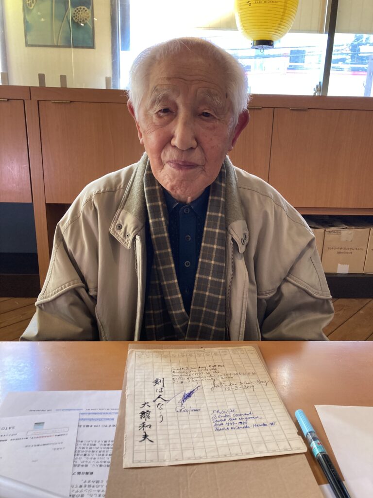Kazuo Odachi having just signed the log book page.